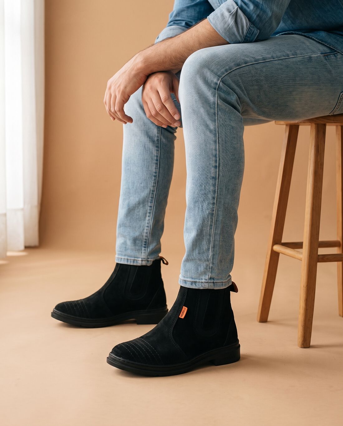 Homem sentado no banco usando a Bota Murielli Preta